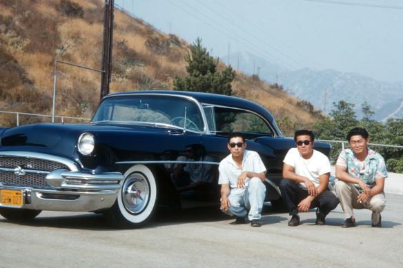 3 guys crouched down by car
